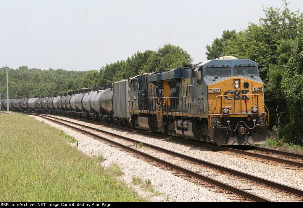 CSX 5438 and 5382 pause with a line of tank cars